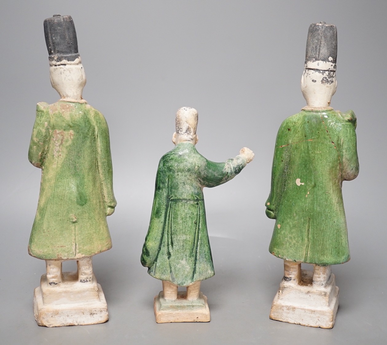 Three Chinese Ming pottery figures of attendants, 28cm tall